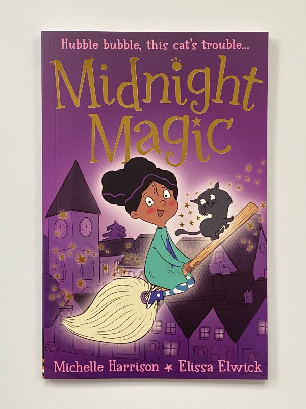 The image shows the cover of Midnight Magic. The book has a purple cover. There is an illustration of a girl and a cat riding a broomstick.