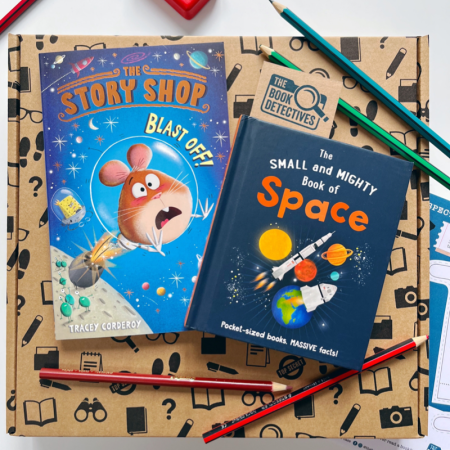 The image shows the contents of the book box which make a great gift for 5 years +. The two books are shown photographed on top of a book detectives postal box. The Story Shop Blast Off has a blue front cover and there is an illustration of a hamster being propelled into space. The Small and Mighty Book of Space has a dark blue front cover and there are illustrations of the sun, planets and rockets on the front.